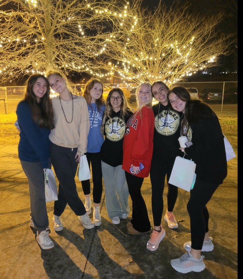 A group of people posing for a photo under a treeDescription automatically generated with medium confidence